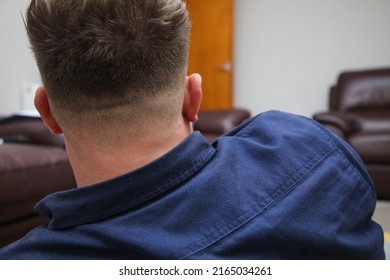 Attractive Male Sitting And Relaxing After A Fresh Shaved Short Skin Fade Haircut Showing The Back Of His Head.