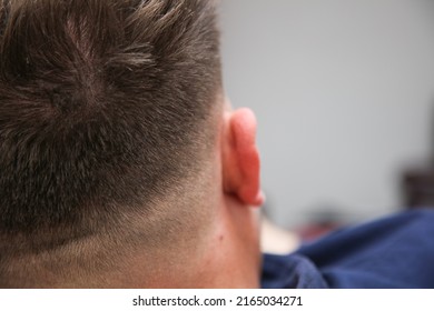 Attractive Male Sitting And Relaxing After A Fresh Shaved Short Skin Fade Haircut Showing The Back Of His Head.