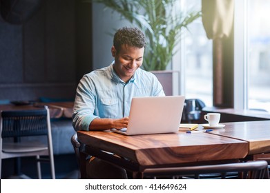 Attractive male worker is using computer in cafeteria  - Powered by Shutterstock