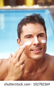 Attractive Man Applying Sunscreen To His Face With His Finger