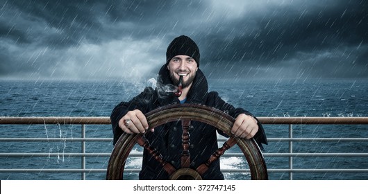Attractive man with beard is driving the ship through rough seas