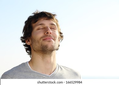Attractive man breathing outdoor with the sky in the background             