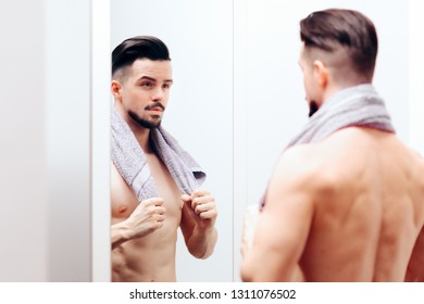 Attractive Man Checking Himself in the Mirror. Attractive guy getting ready following beauty care routine
