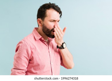 Attractive Man Checking And Smelling His Bad Breath. Hispanic Man With Halitosis Because Of A Bad Dirty Hygiene