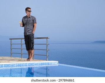 Attractive Man With A Cocktail On An Infinity Pool