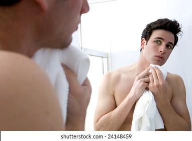 Attractive Man Drying His Face In The Mirror