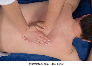 attractive man having a back massage in a spa