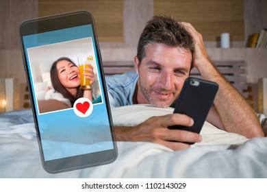 attractive man lying on bed on line searching sex or love finding beautiful girl profile sending like using mobile phone in internet relationship social media dating app and modern lifestyle concept