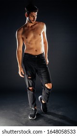 Attractive Man Posing Shirtless In Ripped Black Jeans And Sport Shoes