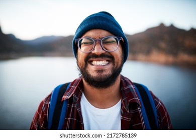 An Attractive Man Pulls A Silly Grin On A Hiking Trip By A Lake