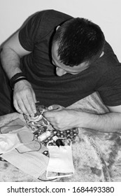 Attractive Man Sewing Face Masks To Prevent Coronavirus At Home