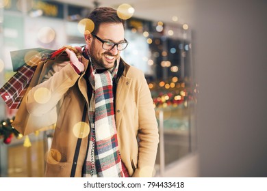 Attractive Man Shopping Holiday Presents And Smiling