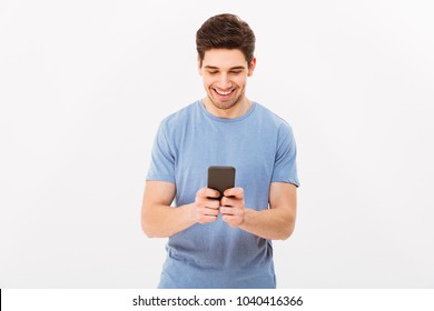 Attractive Man With Short Dark Hair Chatting Or Typing Text Message Using Cell Phone Isolated Over White Background