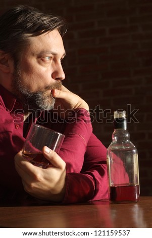 Attractive man sits quietly at his home at the table