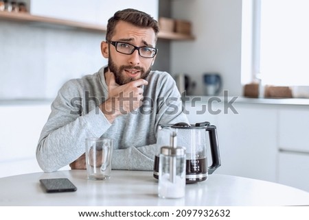 attractive man sitting at the kitchen table in the morning