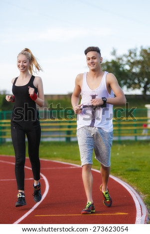 An attractive man and woman jogging on the track
