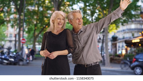 Attractive Mature Couple Hailing A Cab In Paris