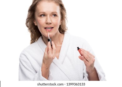 Attractive Mature Woman Applying Lip Gloss Isolated On White 