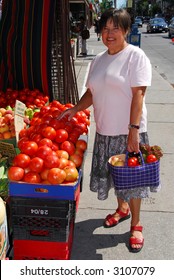 Attractive Mature Woman Buying Vegetables At Fruit Stand