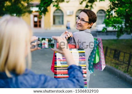 Similar – Image, Stock Photo Twin sisters laughing at a postcard in Erfurt