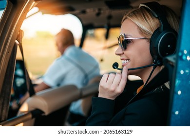 Attractive middle age business woman using private air transport chopper or helicopter to travel to a business meeting.