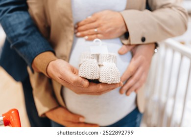 Attractive middle age couple enjoying in buying clothes and appliances for their new baby. Beautiful couple in baby shop or store. Expecting baby concept. - Powered by Shutterstock