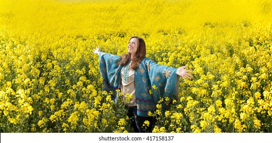 Attractive Middle Age Woman With Arms Outstretched In Flower Field