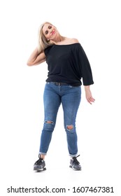 Attractive Middle Aged Blond Hair Woman Adjusting Hair And Looking At Camera In Jeans And Sneakers. Full Body Length Isolated On White Background. 