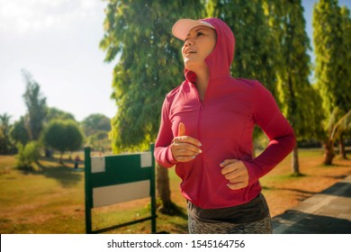 Attractive Middle Aged Lady Running Happy At City Park . Beautiful And Sporty Woman On Her 40s Exercising Doing Jogging Workout On A Sunny Morning Enjoying Healthy Lifestyle And Fitness