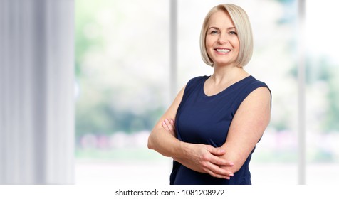 Attractive Middle Aged Woman With Beautiful Smile Near The Window.