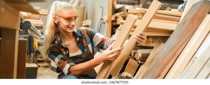 Attractive middle aged woman carpenter designer works with ruler, make notches on the tree in workshop. Image of modern femininity. Concept of professionally motivated women - Powered by Shutterstock