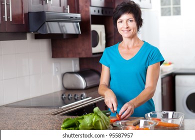 Attractive Middle Aged Woman Cooking In Kitchen