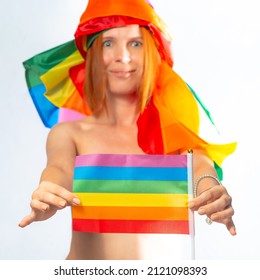 Attractive Middle Aged Woman With Rainbow Flag Coiled Around Her Head Holding A Flag, Isolated On White Background. LGBT International Symbol Of The Lesbian, Gay, Bisexual And Transgender Community