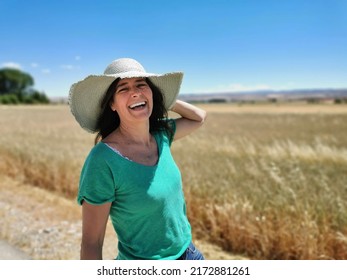 Attractive middle-aged happy woman in a hat enjoying the countryside and holidays - Powered by Shutterstock