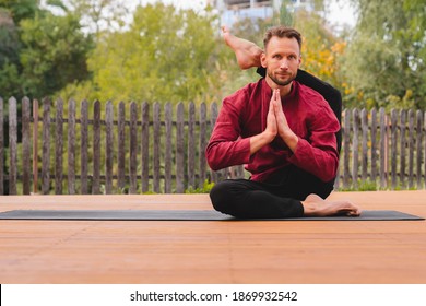 Attractive Middle-aged Male Yogi In One Leg To Head Pose On Mat In The Garden