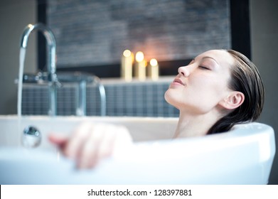 Attraktive gemischte asiatische Frau, die sich im Bad entspannt