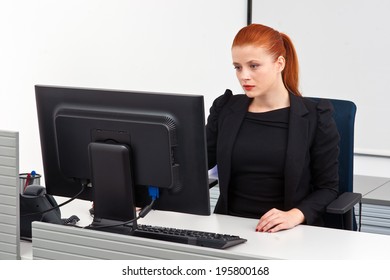 Attractive Modern Red Hair Businesswoman  In Small Office Cubicle Workstation