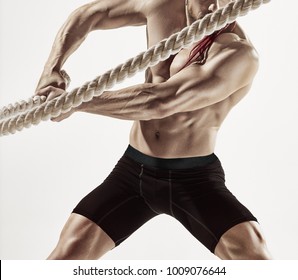 Attractive Muscular Man Working Out With Heavy Ropes. Photo Of Handsome Man In Sportswear Isolated On White Background. Crossfit