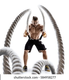Attractive muscular man working out with heavy ropes. Photo of handsome man in sportswear isolated on white background. Crossfit
