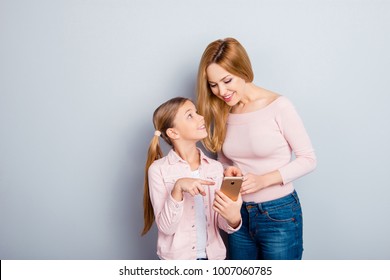 Attractive, Nice, Cute Kid Indicate With Index Finger On Digital Smart Phone Screen To Her Lovely Mother, Showing Something Interesting, Together Doing Online Shopping