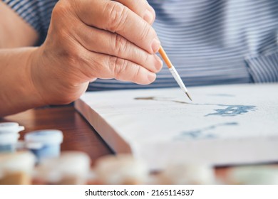 Attractive old woman painting by numbers at home close-up. Inspirational hobby and art therapy. Selective focus - Powered by Shutterstock