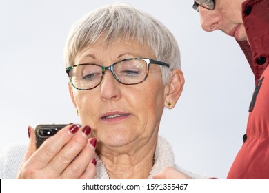 Attractive Older Woman With Glasses And Gray Hair Talking On The Phone With A Young Guy Next Door 