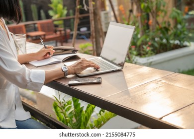 attractive  owner of big company,Portrait of business woman outdoor with coffee and laptop, smiling businesswoman using laptop computer and talking with cellphone, hand with pencil writing on notebook - Powered by Shutterstock