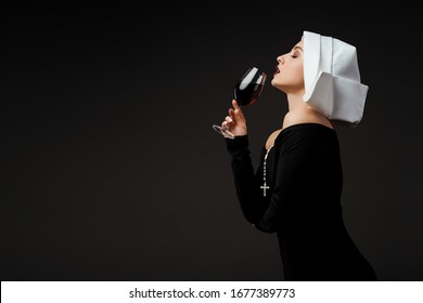 Attractive Passionate Nun Drinking Red Wine From Glass Isolated On Grey