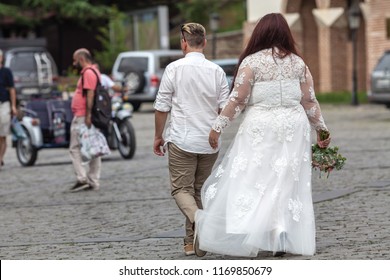 Attractive Plus Size Bride In White Dress On Walk With Groome