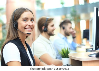 Attractive positive young businesspeople and colleagues in a call center office. - Powered by Shutterstock