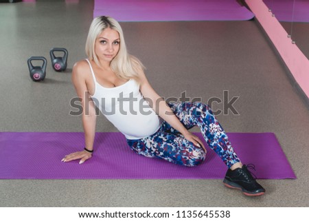 Attractive pregnant woman's doing yoga in the gym with step aerobic, healthy lifestyle