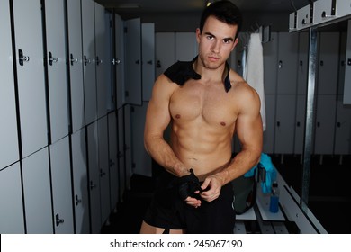 Attractive Professional Athlete Removing Weight Lifting Gloves Standing In Gym's Locker Room