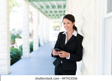 Attractive Real Estate Agent Businesswoman Lawyer Texting With Mobile Phone On House Veranda