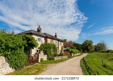 Attractive rural scene in the South Downs area of the South of England featuring traditionally constructed downland flint cottages on a summer day with blue sky